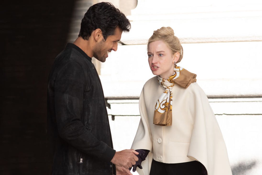 a young woman, dressed in a white coat, yells a man who has a smirk on his face